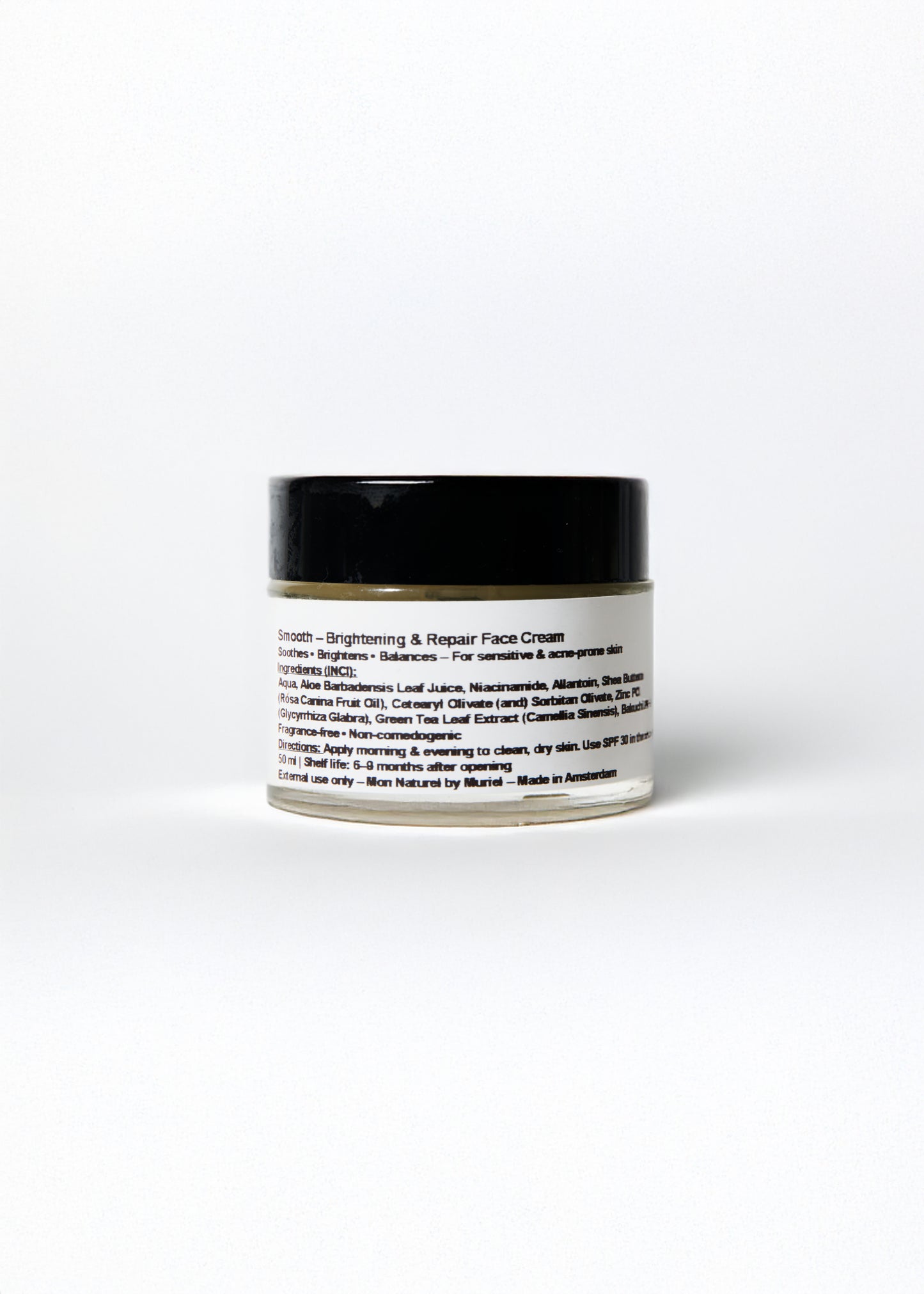 Jar of facial cream with black lid and white label on a white background
